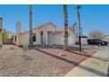 Single-story house with a two-car garage, palm trees, and rock landscaping at 6425 Mountain Mesa Ave, Las Vegas, NV 89156