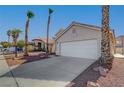 Single story house with a two-car garage and palm trees at 6425 Mountain Mesa Ave, Las Vegas, NV 89156