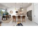 Bright, open kitchen featuring granite countertops, stainless appliances, and a central island with bar stool seating at 91 Alta Cascata Pl, Henderson, NV 89011