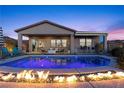 Inviting backyard pool with fire feature and lounge area, perfect for outdoor entertaining and relaxation at dusk at 91 Alta Cascata Pl, Henderson, NV 89011