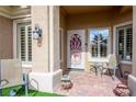 Inviting front porch with tiled flooring, seating, and a decorative door at 9300 Villa Ridge Dr, Las Vegas, NV 89134