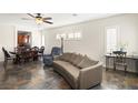 Open-concept living area with tile flooring, a dining set and neutral-colored furnishings at 3992 Welsh Pony St, Las Vegas, NV 89122