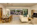 Bright and airy living room featuring an open floor plan, hardwood floors, and sliding doors to the patio at 10528 Meadow Mist Ave, Las Vegas, NV 89135