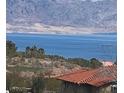 Exterior view of a terracotta-roofed house with lake and mountain views in the scenic background at 117 Forest Ln, Boulder City, NV 89005