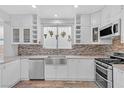 This kitchen features white cabinets, stainless steel appliances, and decorative plants over the sink at 11908 Love Orchid Ln, Las Vegas, NV 89138