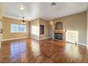Spacious living room featuring hardwood floors, a ceiling fan, ample natural light, and a cozy fireplace at 1851 Hillpointe Rd # 2124, Henderson, NV 89074