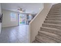 Open-concept layout with tile flooring leading to the kitchen, adjacent to carpeted stairs at 4550 Kali Lyn St, North Las Vegas, NV 89031