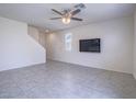 Bright living room with tile floors, ceiling fan and large wall-mounted television at 4550 Kali Lyn St, North Las Vegas, NV 89031