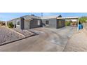 Front view of a gray house with a carport and a gravel driveway at 465 Federal St, Henderson, NV 89015