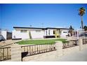 Attractive single-story house with an eye-catching lawn behind a decorative stone fence at 5732 Heron Ave, Las Vegas, NV 89107