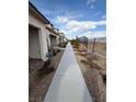 Long walkway along homes with desert landscaping and distant hillside views at 6154 Rathbone St, Las Vegas, NV 89166