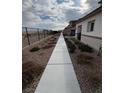 Long walkway alongside the home with desert landscaping and fenced view at 6154 Rathbone St, Las Vegas, NV 89166