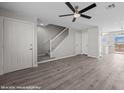 Open-concept living room with laminate floors, ceiling fan, and staircase to the upper level at 700 Aztec Cir # 2E, Mesquite, NV 89027