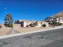 Attractive single-story home with a three-car garage and desert landscaping against a mountain backdrop at 7076 Oakleigh Dr, Las Vegas, NV 89110