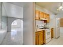 Galley kitchen has oak cabinets, white appliances and tile floors and backsplash at 709 N 22Nd St, Las Vegas, NV 89101