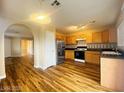 Spacious kitchen featuring stainless steel refrigerator, oak cabinets and modern flooring at 7949 Long Beach St, Las Vegas, NV 89139