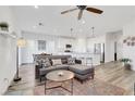 Open-concept living room with modern decor, wood floors, and a seamless flow into the kitchen at 92 Starlight Sonata Ave, Henderson, NV 89015