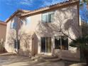 Two-story house back elevation showcasing large windows and a patio at 10046 Daybreak Dew Ct, Las Vegas, NV 89183