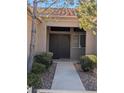 Inviting front entrance with decorative security door, tiled foyer and charming desert landscaping at 10709 Hunters Woods Pl, Las Vegas, NV 89134