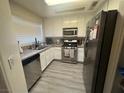 Bright kitchen features stainless steel appliances, white cabinets and granite countertops at 1400 Jamielinn Ln # 102, Las Vegas, NV 89110