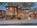 Elegant two-story home with stone accents, lush landscaping, and a three-car garage, perfect for Gathering living at 2124 Pont National Dr, Henderson, NV 89044