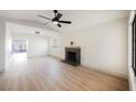 Bright living room featuring a fireplace, ceiling fan, and wood-look floors at 353 Keating St, Henderson, NV 89074