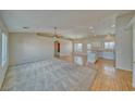 Bright, open-concept living room featuring a ceiling fan, large windows, and wood flooring at 3714 Mount Charleston Dr, Pahrump, NV 89048