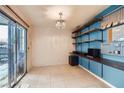 Versatile bonus room featuring built-in shelves, a chandelier, and sliding glass doors leading to an outdoor patio at 3932 Voxna St, Las Vegas, NV 89119