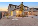 Charming stucco home with desert landscaping, three-car garage, and a welcoming entrance at 4499 Amazing View St, Las Vegas, NV 89129