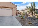 Single-story stucco home with desert landscaping, two-car garage, and gated front entrance at 6151 Moonlight Sonata Ave, Las Vegas, NV 89122