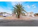 Charming single-story home with mature palm trees and rock accents, set against a clear blue sky at 659 D Ave, Boulder City, NV 89005