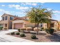 Two-story house with a two-car garage and mature tree in front at 6713 Chambers Lake Ct, North Las Vegas, NV 89084