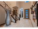 Grand foyer with soaring ceilings, elegant staircase, and artistic decor, creating a welcoming entrance at 8560 Foundry Branch Ln, Las Vegas, NV 89113