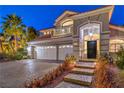 Elegant two-story home featuring an arched entrance, three-car garage, and beautifully landscaped front yard at 8808 Rozetta Ct, Las Vegas, NV 89134