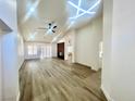 Bright living room featuring a fireplace, vaulted ceiling, fan, and luxury vinyl plank flooring at 9437 January Dr, Las Vegas, NV 89134