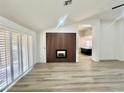 Bright living room featuring a fireplace, natural light from shutters, and luxury vinyl plank flooring at 9437 January Dr, Las Vegas, NV 89134