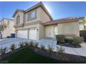 A beige two-story home with a two-car garage and manicured front yard at 9543 Antelope Bend Ct, Las Vegas, NV 89148