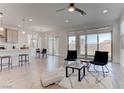 Bright, open-concept living space with tile flooring, modern furnishings, and sliding glass doors to the backyard at 10089 Bismuth St, Las Vegas, NV 89183