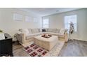 Comfortable living room with a plush sectional sofa, ottoman, and ample natural light at 1132 Ruby Sparrow St, Henderson, NV 89011