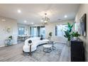 Bright living space featuring a curved sofa, modern light fixtures, and an elegant dining area at 11832 Dragontail Peak Ave, Las Vegas, NV 89138