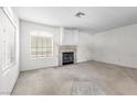 Spacious living room featuring a fireplace, large window, and plush carpeting at 2725 Stars End St, Las Vegas, NV 89108