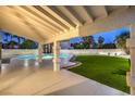 Covered patio offers ample space for outdoor entertaining with views of the pool and manicured lawn at 336 Merit Ct, Henderson, NV 89014