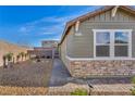 Single-story home featuring stone accents and a low-maintenance gravel yard with a brick walkway at 3491 Argiento Ave, Henderson, NV 89044