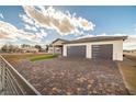 Paver driveway leading to a charming single-story home featuring desert landscaping and a three-car garage at 3520 Malibou Ave, Pahrump, NV 89048