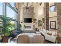 Spacious living room boasts a stone fireplace, tall windows, and comfortable seating area at 5764 Aspen Falls Cir, Las Vegas, NV 89149
