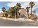 Attractive corner-lot home with palm trees, desert landscaping, and a gated driveway entrance at 6588 Aldergate Ln, Las Vegas, NV 89110