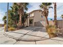 Corner lot home with desert landscaping and a long driveway leading to a gated entrance at 6588 Aldergate Ln, Las Vegas, NV 89110