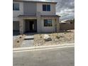 Two-story home featuring stone accents, desert landscaping, and a modern architectural design at 7199 Twilight Rider Ct, Las Vegas, NV 89118