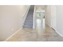 Bright foyer featuring tile floors, a carpeted staircase, and neutral paint throughout the space at 7629 Rosebark Cliffs St, North Las Vegas, NV 89084