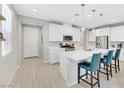 Bright, modern kitchen with white cabinets, stainless steel appliances, and a center island with seating at 787 Cottonwood Hill Pl, Henderson, NV 89011